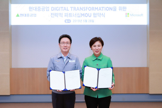 김태환 현대중공업 전무(왼쪽)와 이지은 한국MS 부사장이 클라우드 도입을 포함한 디지털 혁신 관련 MOU를 맺고 사진촬영을 하고 있다. 한국MS 제공